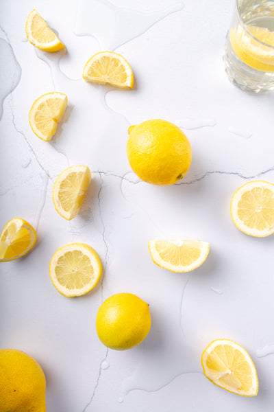 White old wall backdrop with on top splashed lemons with water to show that the vinyl backdrops are waterproof.