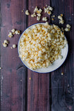 Backdrop with wood print for background photography for social media and instagram background. Popcorn on a plate to demonstrate the use of the vinyl backdrop